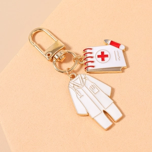 Detail of medical keychain with white nurse uniform and medical notebook charms