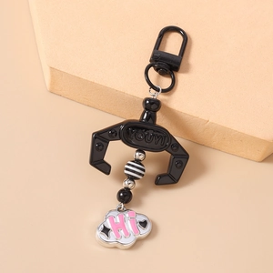 Detail of creative claw machine keychain with black metal clip and striped beads