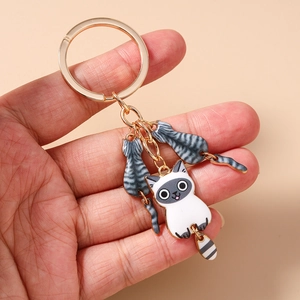 Gros plan du porte-clés doré avec d'adorables pendentifs de chats de dessin animé