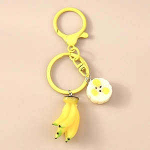 Detailed close-up of a realistic banana keychain with yellow fruit charms and metal ring