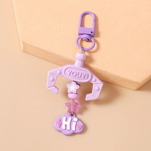 Detail of purple claw crane keychain with cloud pendant and star beads hanging on hook