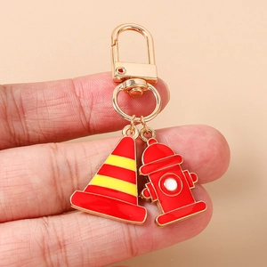 Detailed close-up of a metal firefighter keychain with red fire hydrant and traffic cone