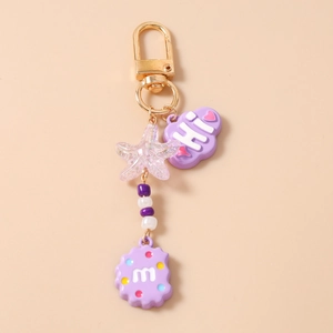 Close-up of cute purple keychain with glitter star, HI cloud, and letter M charm