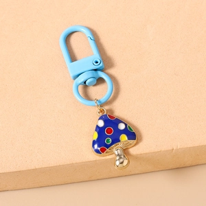 Detailed view of colorful polka dot mushroom keychain with blue carabiner and gold metal stem