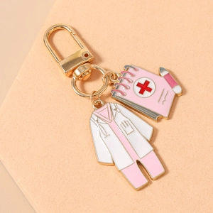 Detailed view of gold nurse uniform and pink medical notebook enamel pendants on keychain