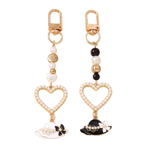 Elegant beaded heart keychain set with pearl accents and chic black and white hat pendants