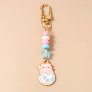 Détail du porte-clés dinosaure avec perles pastel et fermoir en métal doré