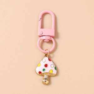 Detailed view of pink metal lobster clasp and colorful polka dot mushroom keychain