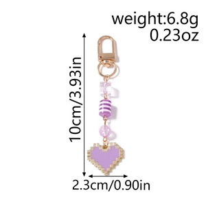 Detail showing pixel heart keychain dimensions, purple beads and golden metal spring clasp