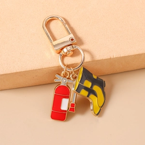 Detail of metal keychain featuring red fire extinguisher and yellow fire boot pendants