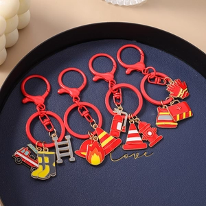 Detail of firefighter enamel keychains featuring fire trucks and fire hydrants on red clasps
