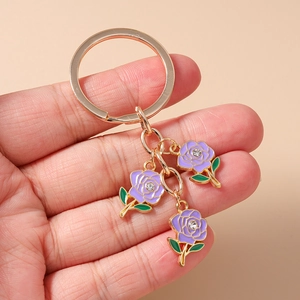Exquisite purple enamel rose keychain with crystal accents held in hand to show size