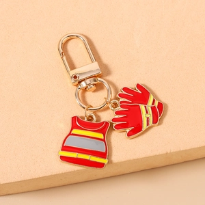 Detail of firefighter keychain with red rescue vest and gloves enamel charms on gold clasp