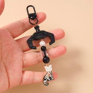 Detail of beaded cat skeleton keychain featuring black beads and crescent moon charm