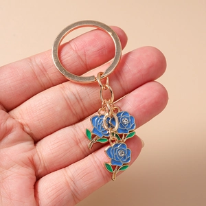 Detailed macro view of gold plated keychain with blue roses and sparkling white rhinestones