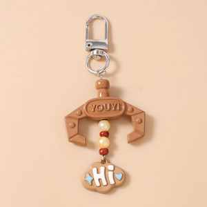Close-up of a brown claw crane keychain with colorful beads and a blue star cloud charm
