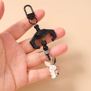 Detail view of mechanical rabbit keychain with metal claw and decorative beads
