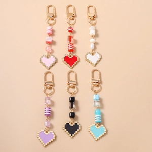 Detail view of colorful pixel heart keychains with acrylic beads and gold spring hooks