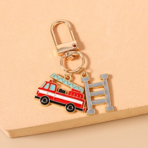 Detail of red enamel fire truck and grey ladder pendant on golden keychain hook