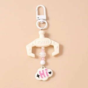 Close-up of a pink beaded claw machine keychain with cloud charm and Hi lettering