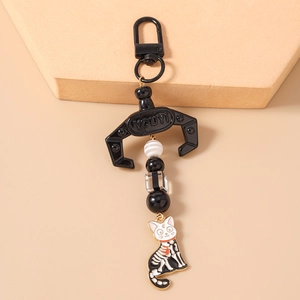 Detail of beaded animal keychain with black mechanical claw and Luna cat charm