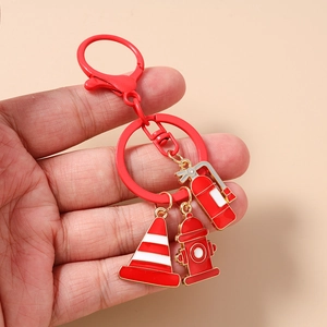 Detail of red fire safety keychain set with hydrant, extinguisher and cone charms