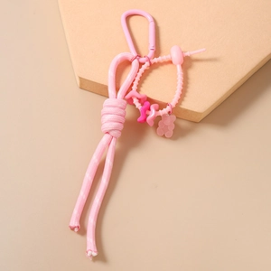 Détail d'un pendentif ours rose avec corde en nylon et mousqueton sur socle d'expo