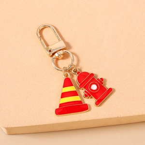 Detail of creative fire hydrant and traffic cone charms on gold keychain hook