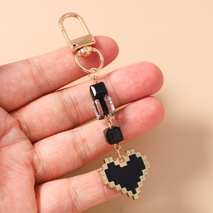 Close-up of golden lobster clasp with black beaded pixelated heart charm for bags