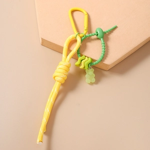 Vue détaillée du bijou de sac en nylon tissé main avec ours en résine et mousqueton jaune