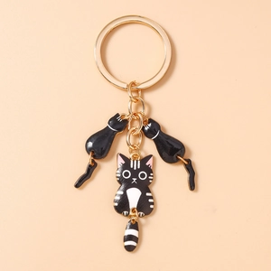 Vue détaillée de charmants pendentifs chats à rayures noires et blanches sur porte-clés doré