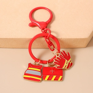 Detailed close-up of firefighter key ring featuring red vest, first aid kit, and glove charms