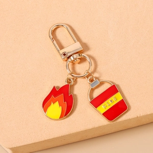 Macro view of firefighter keychain with enamel fire and bucket charms on golden metal ring