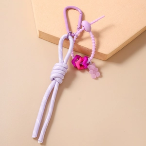 Gros plan sur cordon en nylon tressé violet avec pendentif ours et perles