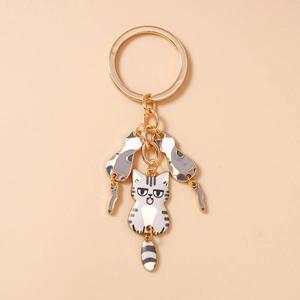 Détail de porte-clés chat mignon doré avec chat à rayures grises et finition émail