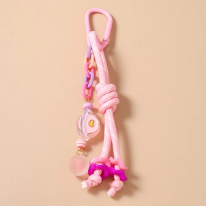 Détail du porte-clés en corde tressée rose avec pendentif planète cœur et perles colorées