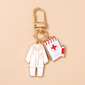 Close-up of doctor themed metal keychain with lab coat and notepad charms on gold ring