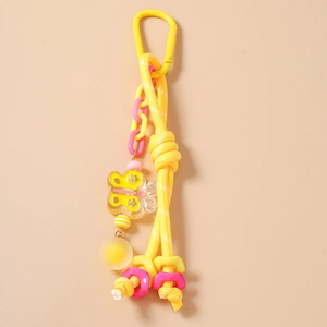 Détail d'un pendentif papillon avec corde tressée jaune et mousqueton en métal