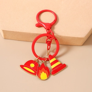 Detail of firefighter keychain featuring red helmet, flame, and cone charms on lobster clasp