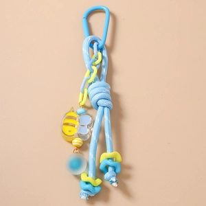 Détail d'un porte-clés tressé bleu clair avec pendentif abeille et chaîne en plastique
