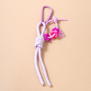 Détail d'un porte-clés en nylon tressé violet avec ours translucide et clip en métal