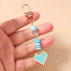 Detail of beaded pixel heart keychain with sky blue beads and golden lobster clasp