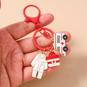 Detail of medical keychain with ambulance, nurse uniform and first aid kit charms