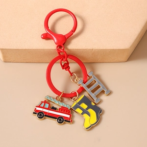 Detailed close-up of firefighter keychain with red truck, yellow boot and silver ladder charms