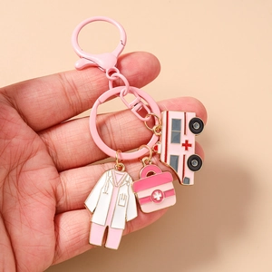 Close-up of pink enamel nurse keychain with medical charms like ambulance and coat