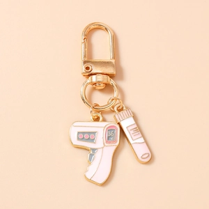 Detail of pink medical keychain featuring a thermometer and test tube with gold finish