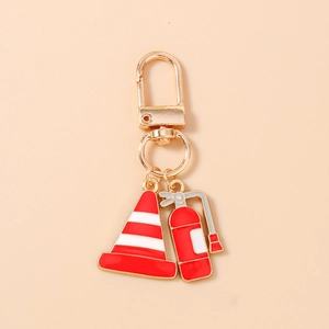 Detail of firefighter keychain with red extinguisher and traffic cone enamel charms