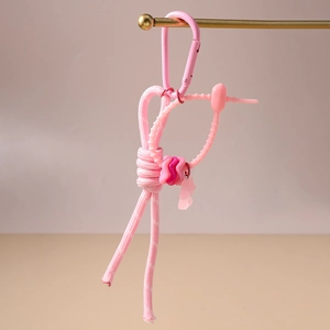 Vue détaillée d'une breloque de sac en nylon tressé rose avec pendentif ours en résine