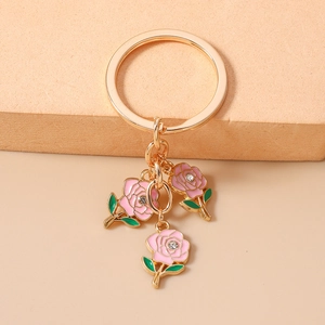 Detail view of pink enamel roses keychain with golden ring and sparkling crystal centers