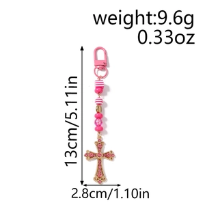 Vue détaillée des dimensions du porte-clés à perles rayées roses avec pendentif croix strass